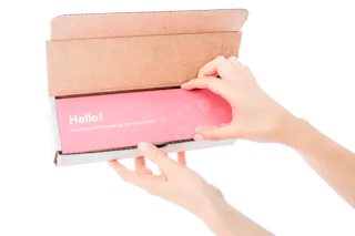 Hands opening a brown box containing a pink package labeled 