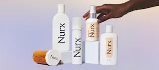 A hand arranges skincare and pharmaceutical bottles labeled 