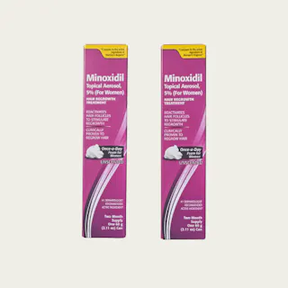 Two pink boxes of Minoxidil Topical Aerosol, 5% for women, are displayed. The product is for hair regrowth treatment and is unscented.