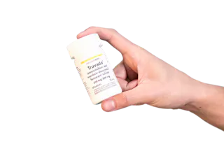 A person holding a white bottle labeled 