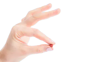A hand holding a small brown pill between the thumb and index finger against a white background.