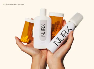 Hands holding three medication bottles and one spray bottle labeled 