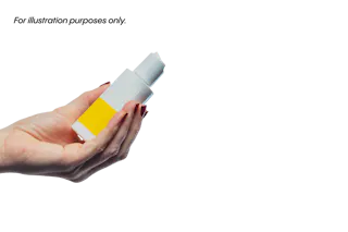 Hand holding a white bottle with a yellow label on a black background.