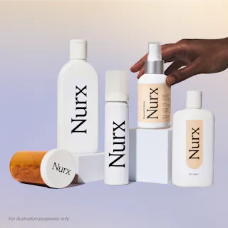 A hand arranges skincare and pharmaceutical bottles labeled 